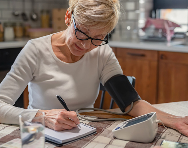Older woman checking blood pressure at home