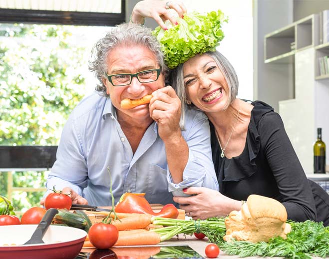 Senior-couple-having-fun-in-kitchen-cooking-healthy-food-togethe